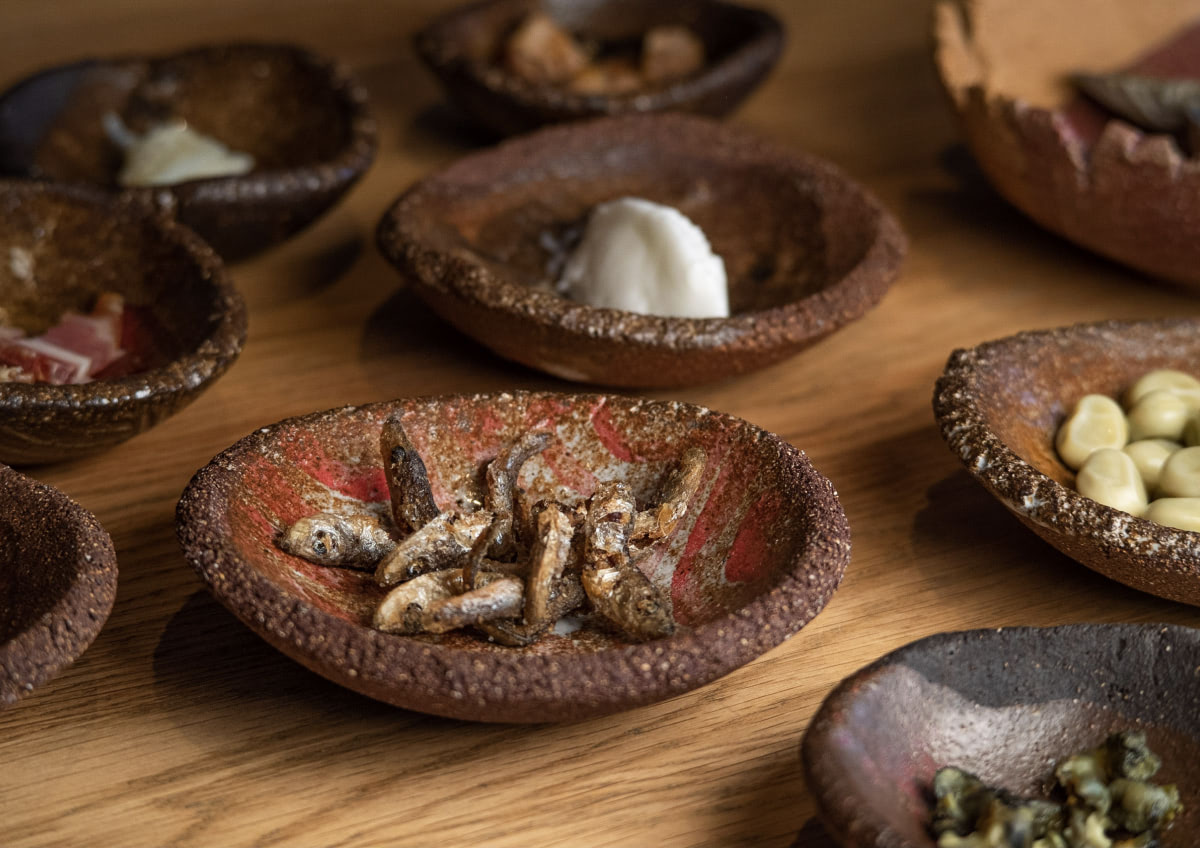 Cuencos con sardinas fritas, habas, leche mecida...